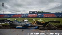 TOPSHOT - Discarded shoes sit by the pitch at Kanjuruhan stadium days after a deadly stampede following a football match in Malang, East Java on October 3, 2022. - Anger against police mounted in Indonesia on October 3 after at least 125 people were killed in one of the deadliest disasters in the history of football, when officers fired tear gas in a packed stadium, triggering a stampede. (Photo by Juni Kriswanto / AFP) (Photo by JUNI KRISWANTO/AFP via Getty Images)