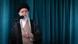 Iran's supreme leader standing in front of a microphone and looking out of the frame Iran's supreme leader standing in front of a microphone and looking out of the frame