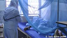 Ein Mann liegt hinter einem Moskitonetz in einem Krankenhausbett nach einer Dengue Infektion in Pakistan 
