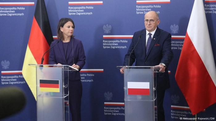 Bundesaußenministerin Annalena Baerbock steht hinter einem Pult mit einer schwarz-rot-goldenen Deutschlandflagge, rechts daneben steht polnische Außenminister Zbigniew Rau hinter einem Pult, auf dem die weiß-rote Flagge Polens prangt