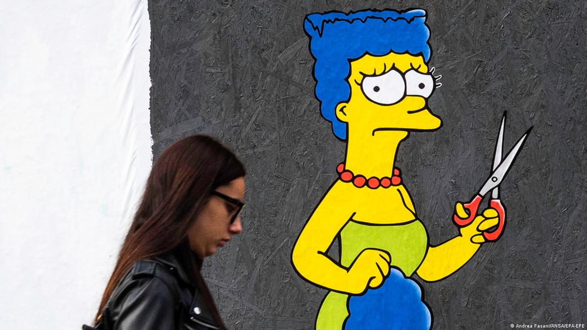 Marge Simpson com parte do cabelo cortado na mão em parede em Milão