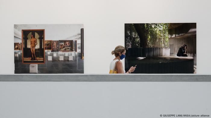 Eine Person läuft aufs Handy blickend an zwei Fotografien von Isaac Julien vorbei. Eine Person läuft aufs Handy blickend an zwei Fotografien von Isaac Julien vorbei.