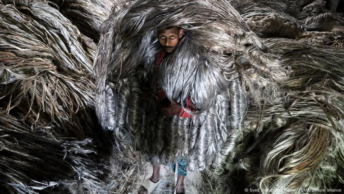 Bangladesh es el segundo mayor productor de yute en el mundo, un producto totalmente ecológico, sostenible y biodegradable. Debido a su color dorado y sedoso, se le llama fibra dorada. En esta imagen, un hombre lleva sobre su cabeza una carga de yute que pesa 50 kg. 