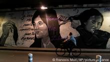 05.10.2022 FILE - A woman rides bicycle front of a mural signed by Clacks-one and Heartcraft_Street art, depicting women cutting their hair to show support for Iranian protesters standing up to their leadership over the death of a young woman in police custody, in a tunnel in Paris, France, Wednesday, Oct. 5, 2022. The mother of a 16-year-old Iranian girl has disputed official claims, Friday, Oct. 7, that her daughter fell to her death from a high building, saying the teen was killed by blows to the head as part of the crackdown on anti-hijab protests roiling the country. Nika Shakarami has become the latest icon of the protests, seen as the gravest threat to Iran’s ruling elites in years. (AP Photo/Francois Mori)