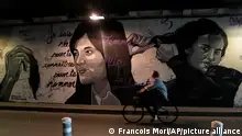 05.10.2022 FILE - A woman rides bicycle front of a mural signed by Clacks-one and Heartcraft_Street art, depicting women cutting their hair to show support for Iranian protesters standing up to their leadership over the death of a young woman in police custody, in a tunnel in Paris, France, Wednesday, Oct. 5, 2022. The mother of a 16-year-old Iranian girl has disputed official claims, Friday, Oct. 7, that her daughter fell to her death from a high building, saying the teen was killed by blows to the head as part of the crackdown on anti-hijab protests roiling the country. Nika Shakarami has become the latest icon of the protests, seen as the gravest threat to Iran’s ruling elites in years. (AP Photo/Francois Mori)