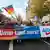 A street demonstration of AfD leaders and supporters holding a banner reading 'our country first!'