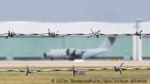 Ein Blick durch Stacheldraht am Fliegerhorst Wunstorf der Luftwaffe in der Region Hannover auf ein Transportflugzeug vom Typ Airbus A400M der Luftwaffe (Unschärfeeffekt durch offene Blende). Angesichts des rasanten Vormarschs der Taliban in Afghanistan will die Bundeswehr am Montag (16.08.2021) mit der Evakuierung deutscher Staatsbürger und afghanischer Ortskräfte aus Kabul beginnen.