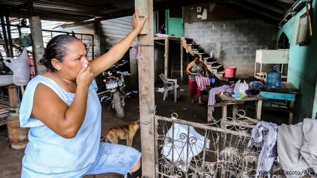 Una mujer se prepara para salir de su casa en el municipio de El Progreso, Honduras, ante la llegada de la tormenta tropical Julia.