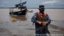 A Navy soldier stands guard as authorities wait for the arrival of people who were evacuated from the Monkey Point community, at the port in Bluefields, Nicaragua, Friday, July 1, 2022. Bonnie has formed over the Caribbean as it heads for a quick march across Central America and potential development into a hurricane after reemerging in the Pacific. (AP Photo/Inti Ocon)