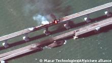 This satellite image provided by Maxar Technologies shows damage to the Kerch Bridge, which connects the Crimean Peninsula with Russia crossing a strait between the Black Sea and the Sea of Azov, and rail cars on fire on Saturday, Oct. 8, 2022. (Maxar Technologies via AP)