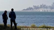 08/10/2022***
People look at thick black smoke rising from a fire on the Kerch bridge that links Crimea to Russia, after a truck exploded, near Kerch, on October 8, 2022. - Moscow announced on October 8, 2022 that a truck exploded igniting a huge fire and damaging the key Kerch bridge -- built as Russia's sole land link with annexed Crimea -- and vowed to find the perpetrators, without immediately blaming Ukraine. (Photo by Roman DMITRIYEV / AFP) (Photo by ROMAN DMITRIYEV/AFP via Getty Images)