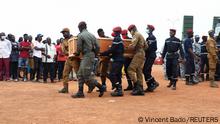 Burkina Faso soldiers carry a coffin of one of the 27 soldiers killed in an attack by Islamist militants on a convoy that was taking supplies to a town in northern Burkina Faso, during their burial ceremony in Ouagadougou, Burkina Faso October 8, 2022. REUTERS/Vincent Bado