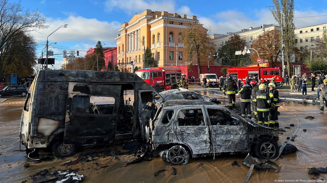 Carros destruídos. Ao lado, bombeiros com veículos