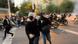 Mulheres correndo em rua onde ocorre protesto popular Mulheres correndo em rua onde ocorre protesto popular