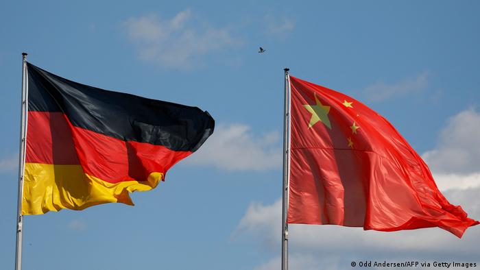 Die deutsche und die chinesische Flagge vor blauem Himmel mit leichter Bewölkung