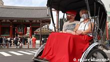 Tourists from Germany enjoy riding in a jinrikisha, a Japanese rickshaw, around Asakusa in Tokyo on Oct. 11, 2022. Quarantine policy for Coronavirus COVID-19 infections was eased with the cap of 50,000 daily visitors to Japan removed and the ban on individual travel by foreigners to Japan lifted on the same day. ( The Yomiuri Shimbun via AP Images )
