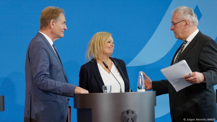 Pressekonferenz nach dem Spitzengespräch von Bund, Ländern und Kommunen zur aktuellen Flüchtlingslage im Bundesinnenministerium. Nancy Faeser SPD, Bundesministerin des Inneren und für Heimat, steht an einem Rednerpult. Rechts von ihr steht Joachim Herrmann CSU, Innenminister des Freistaates Bayern, der mit ihr spricht. Auf der linken Seite steht Burkhard Jung SPD, Vizepräsident des Deutschen Städtetages und Oberbürgermeister der Stadt Leipzig, der den beiden zuhört. Pressekonferenz nach dem Spitzengespräch von Bund, Ländern und Kommunen zur aktuellen Flüchtlingslage im Bundesinnenministerium. Nancy Faeser SPD, Bundesministerin des Inneren und für Heimat, steht an einem Rednerpult. Rechts von ihr steht Joachim Herrmann CSU, Innenminister des Freistaates Bayern, der mit ihr spricht. Auf der linken Seite steht Burkhard Jung SPD, Vizepräsident des Deutschen Städtetages und Oberbürgermeister der Stadt Leipzig, der den beiden zuhört.