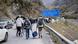 Travelers walking on the road from Verkhni Lars customs checkpoint between Georgia and Russia Travelers walking on the road from Verkhni Lars customs checkpoint between Georgia and Russia