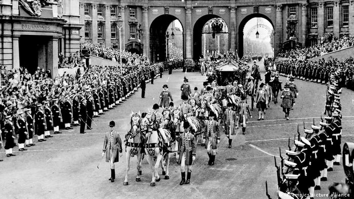 La carroza real de Estado lleva a la Reina Isabel II y al Duque de Edimburgo pasando por Admiralty Arch de camino a Westminster para la coronación el 2 de junio de 1953. La ceremonia fue la primera en su tipo transmitida en vivo por la televisión.