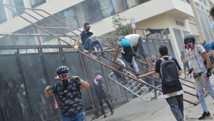 protesters scaling the gates of Lebanon's parliament building