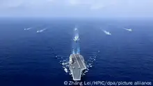 --FILE--In this aerial view, China's aircraft carrier, The Liaoning, of the PLA (People's Liberation Army) is followed by destroyers and frigates during a naval exercise in the western Pacific, 18 April 2018. The People's Liberation Army Navy has made tremendous strides over the past few years in transforming itself into a world-class force under guidance and instructions from President Xi Jinping, according to top Navy commanders. The PLA Navy was founded on April 23, 1949. To celebrate its 70th birthday, a host of multinational naval activities, including a joint sea parade, high-level symposiums and public tours of ships, are being held in Qingdao and nearby waters this week through Thursday (25 April 2019).