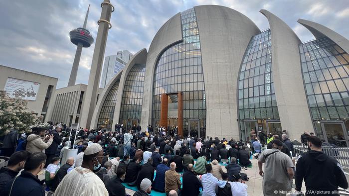 People gather to perform Eid al-Fitr prayer at Cologne Central Mosque in Cologne