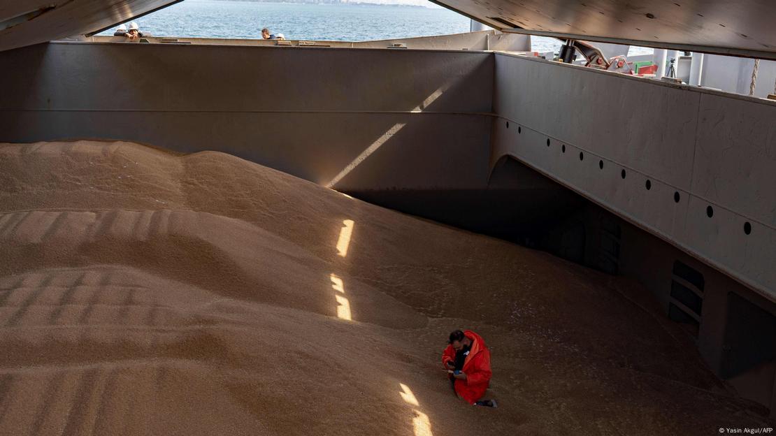 Homem inspeciona carregamento de grãos em navio