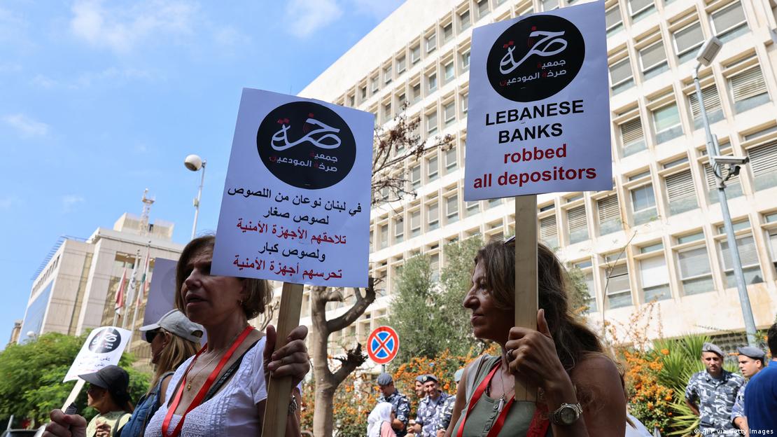 Demonstrators carry banners during a protest organised by "Depositors' Outcry" to ask for their deposits blocked in Lebanese banks, on October 5, 2022 outside Lebanon's Central Bank in Beirut.