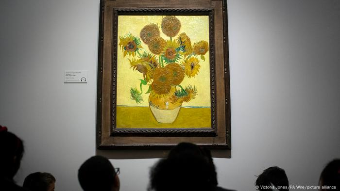 Hinterköpfe vor dem Gemälde Sonnenblumen von Vincent van Gogh.