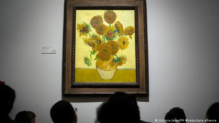 Hinterköpfe vor dem Gemälde Sonnenblumen von Vincent van Gogh.