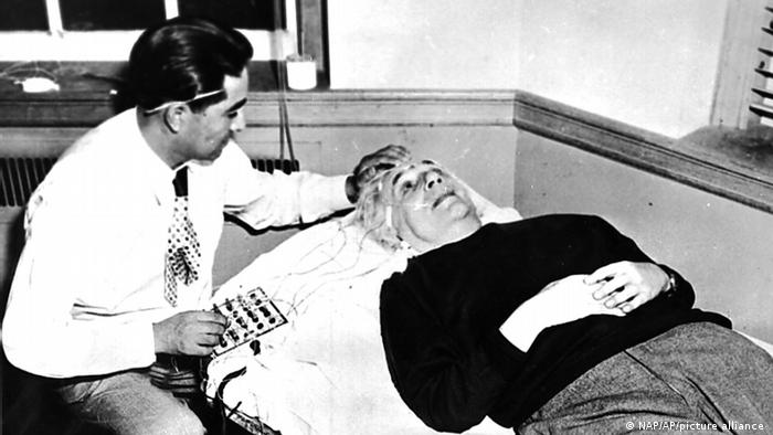 Diminutos electrodos metálicos son colocados en la cabeza del famoso científico Albert Einstein para recoger los impulsos de su cerebro y ampliarlos y grabarlos para su estudio. El Dr. Alejandro Arellano está sentado junto a Einstein en esta foto de archivo de septiembre de 1950 en Princeton, Nueva Jersey.