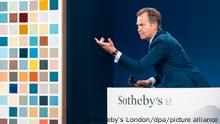 Oliver Barker, Chairman Sotheby’s Europa und Auktionator der Contemporary Evening Auction, versteigert das Gemälde «192 Farben» (l) des Malers Gerhard Richter. Das Bild ist am Freitagabend für 20,9 Millionen Euro in London versteigert worden. Das 1966 in Düsseldorf entstandene Gemälde gilt als Schlüsselwerk des Malers, der einer der teuersten und einflussreichsten lebenden Künstler der Welt ist. +++ dpa-Bildfunk +++