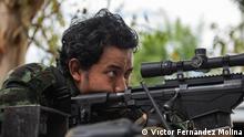 Thu Rain, soldier of the People Defence Forces, watches a Burmese military base through the scope of his roger sniper rifle, Karen State, September of 2022. Víctor Fernández
