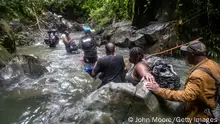 DARIEN GAP, COLOMBIA - OCTOBER 18: Immigrant families, most from Haiti make one of dozens of river crossings on the first day of their trek on October 18, 2021 through the Darien Gap, Colombia. The 66-mile passage through dense rainforest and mountains is considered the most difficult stretch for migrants traveling from South America to the United States. Guides accompany them on the two-day trek to the border with Panama, after which they are on their own for an additional several day hike when they are most vulnerable to bandits and other hazards on the trail. More than 70,000 migrants have traveled through the Darien Gap this year, according to Panamanian authorities. Most of the migrants in recent months have been Haitians, many of whom had been living in Chile and Brazil since the 2010 Haitian earthquake. The Darien Gap, which connects North and South America, is where the Panamerican Highway was never completed due to severe terrain, high cost and myriad environmental concerns. (Photo by John Moore/Getty Images)