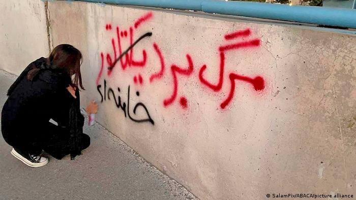 Teheran (15.10.2022): kobieta bez chusty pisze na ścianie „Śmierć dyktatorowi Chamenei” 