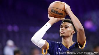 Das französische Basketball-Supertalent Victor Wembanyama hat den Ball über den Kopf gehoben und ist kurz davor zu werfen. 
