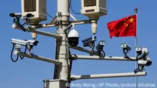 A Chinese national flag flutters near the surveillance cameras mounted on a lamp post in Tiananmen Square in Beijing, Friday, March 15, 2019. Chinese Premier Li Keqiang on Friday denied Beijing tells its companies to spy abroad, refuting U.S. warnings that Chinese technology suppliers might be a security risk. (AP Photo/Andy Wong)