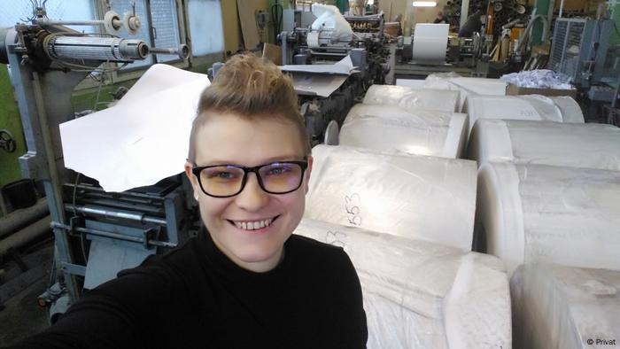 Lilija Wezhewatowa in einer Fabrikhalle mit riesigen Papierrollen