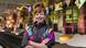 Artist Heather Phillipson smiling with her arms crossed in a colorful exhibition setting. Artist Heather Phillipson smiling with her arms crossed in a colorful exhibition setting.