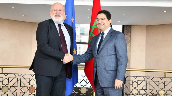 El vicepresidente de la Comisión Europea, Frans Timmermans, y el ministro de Exteriores marroquí, se estrechan sonrientes la mano ante las cámaras.