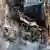 Ukraine Krieg | Angriff russische Drohnen in Kiew. Ein Haus ist von einer Drohne getroffen und zerstört worden. Die Aufnahme wurde am 17. Oktober gemacht. Feuerwehrleute stehen im Schutt, im Vordergrund ist Rauch zu sehen.