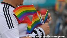 A Germany fan holding rainbow flags