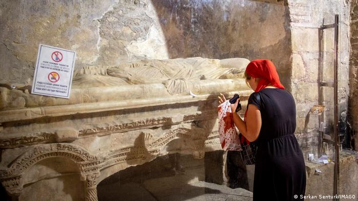 Turistas ortodoxos rezan ante la tumba, el sarcófago de San Nicolás el Maravilloso de Myra.