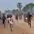 Des jeunes courent dans la rue le 20 octobre 2022 à Moundou, au Tchad