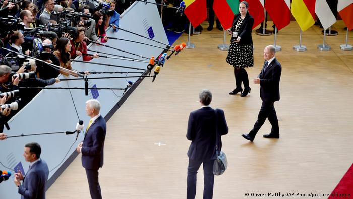 المستشار الألماني أولاف شولتس (يمين) في طريقه إلى الكاميرات والميكروفونات في قمة الاتحاد الأوروبي في بروكسل (20 أكتوبر/ تشرين الأول 2022)