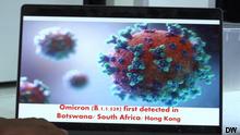 An image of the omicron virus shown on a screen