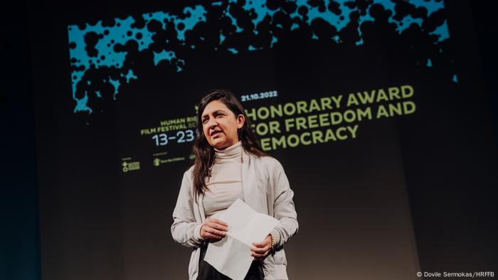 Pegah Edalatian steht beim Human Rights Film Festival Berlin auf der Bühne und hält ein Blatt in der Hand. 