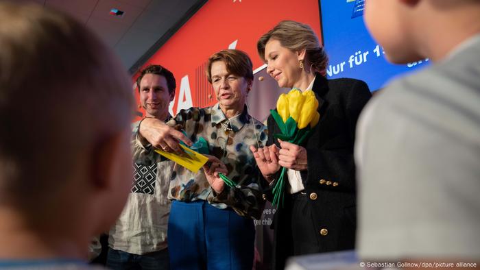 Olena Selenska gucken lächelnd auf Geschenke, die sie in der Hand halten. Olena Selenska gucken lächelnd auf Geschenke, die sie in der Hand halten.