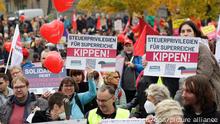 Transparente mit der Aufschrift «Steuerprivilegien für Superreiche kippen!» sind im Invalidenpark bei einer Demonstration zu sehen. Ein Sozialbündnis hat angesichts von Preissteigerungen, Energie- und Klimakrise zu bundesweiten Demonstrationen aufgerufen. +++ dpa-Bildfunk +++