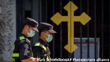 Security officers on patrol walk past the gates of the Wangfujing Church, a Catholic church in Beijing, Wednesday, Sept. 14, 2022. Chinese President Xi Jinping's first trip overseas since the early days of the COVID-19 pandemic will overlap with a visit by Pope Francis to Kazakhstan, although the Vatican says there are no plans for them to meet. (AP Photo/Mark Schiefelbein)